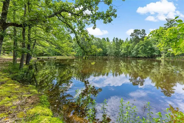 a backyard of a house with table and chairs under an umbrella