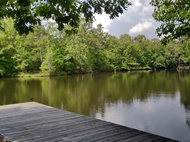 a wooden pier with boats in a lake