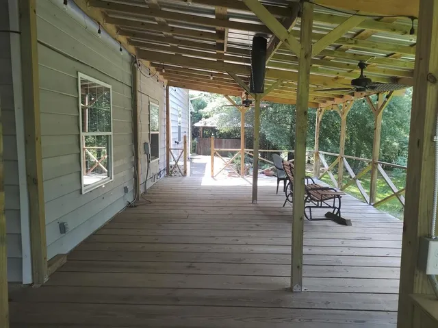 a view of a patio with table and chairs with wooden floor and fence