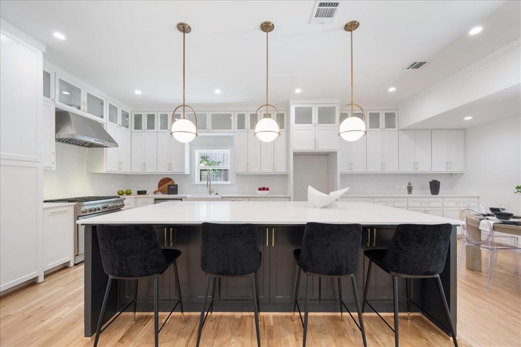 a kitchen with a dining table chairs sink and cabinets