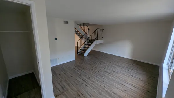 a view of an empty room with wooden floor