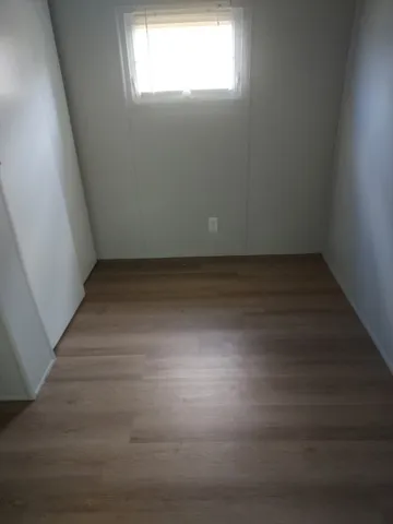 a view of a room with wooden floor and window