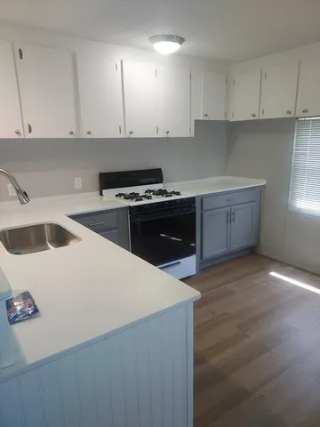 a kitchen with a sink a stove and cabinets