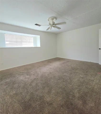 a view of an empty room with a chandelier fan
