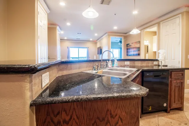 a kitchen with granite countertop a sink a counter and window