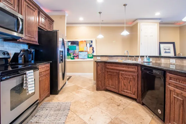 a kitchen with stainless steel appliances granite countertop a stove a sink and a microwave