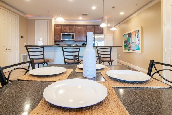 a kitchen with stainless steel appliances a dining table and chairs