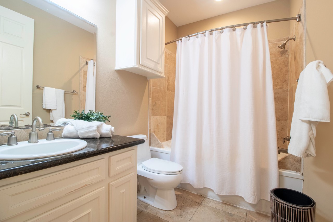 7039 Kingston Cove Lane, Unit 307 Willis, TX 77318 - Photo 8 of 11 a bathroom with a granite countertop sink and a mirror