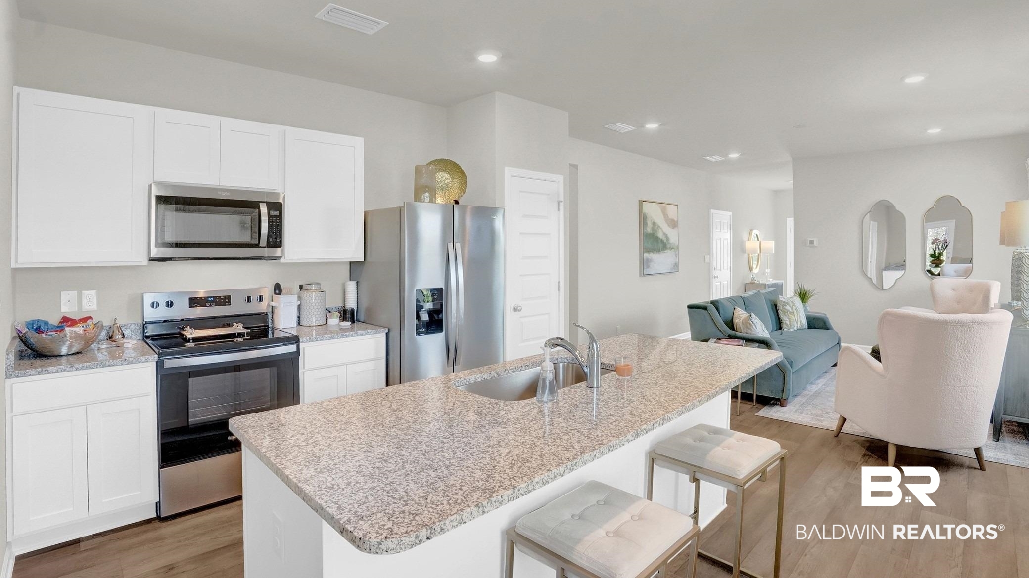 13330 Shea Circle Foley, AL 36535 - Photo 8 of 15 Open-concept kitchen featuring white cabinetry, stainless steel appliances, granite countertops, and wood-finish flooring