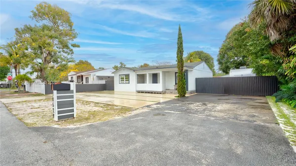 a view of a house with backyard and a tree