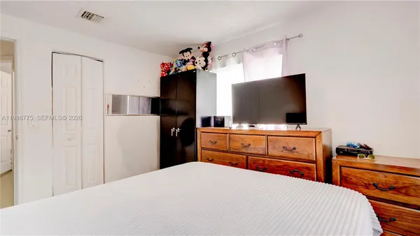 a bedroom with a bed and a flat screen tv