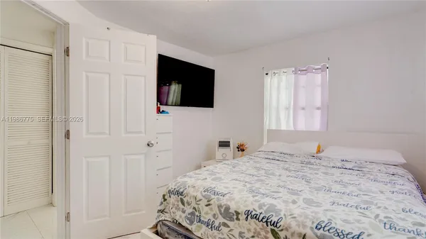 a bedroom with a bed and a flat screen tv