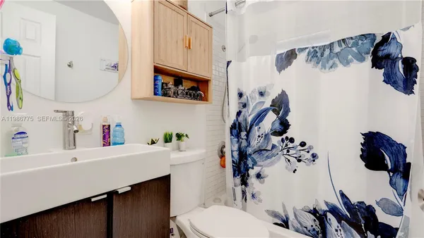 a bathroom with a sink vanity mirror and toilet