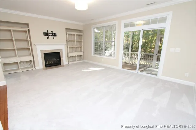 a view of an empty room with a fireplace and a window