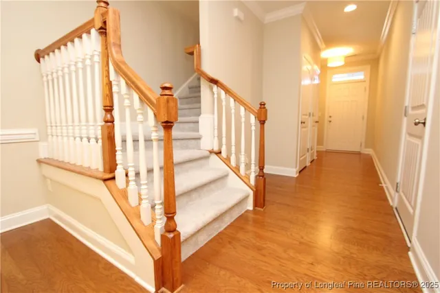 a view of staircase with railing and a rug
