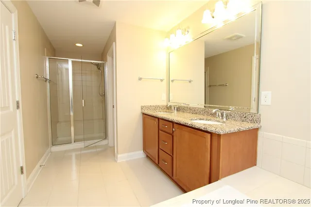 a bathroom with a granite countertop tub sink and mirror