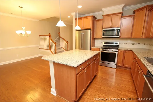 a kitchen with stainless steel appliances granite countertop a sink a stove and a refrigerator