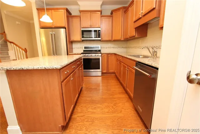 a kitchen with stainless steel appliances granite countertop a refrigerator a stove top oven a sink and dishwasher
