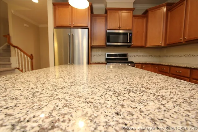 a kitchen with stainless steel appliances a refrigerator and a stove top oven