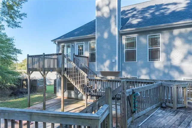 a view of house with a small yard and wooden floor and fence