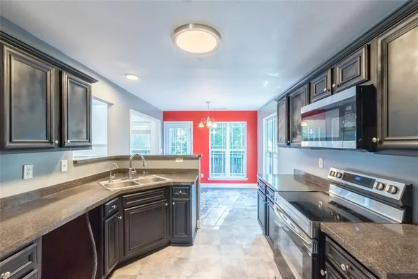 a kitchen with stainless steel appliances granite countertop a sink stove and cabinets