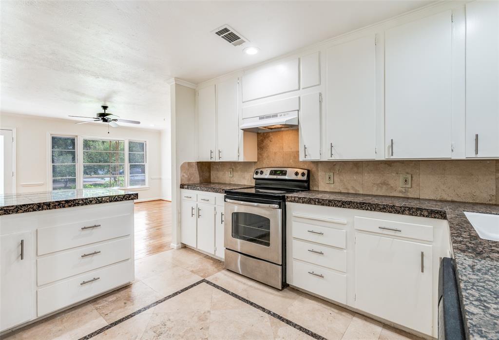 529 Roberts Cut Off Road River Oaks, TX 76114 - Photo 4 of 12 Kitchen featuring tile counters, stainless steel electric range oven, white cabinets, backsplash, and inlaid floor details