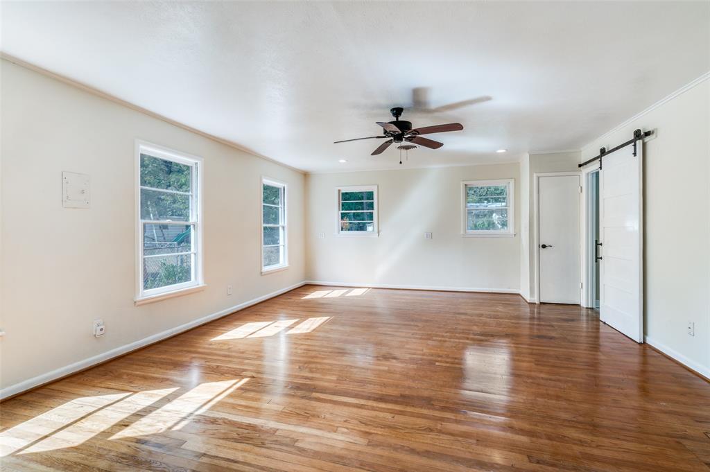 529 Roberts Cut Off Road River Oaks, TX 76114 - Photo 5 of 12 Empty room with a barn door, hardwood / wood-style floors, ceiling fan, and crown molding