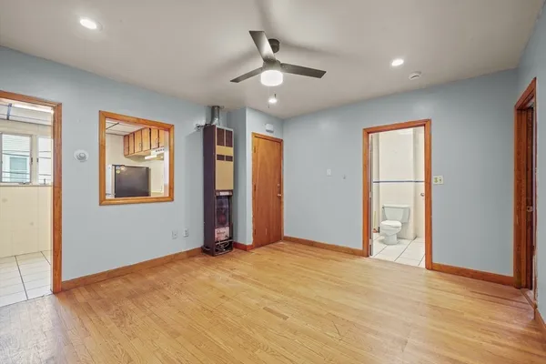 a view of an empty room with window and wooden floor