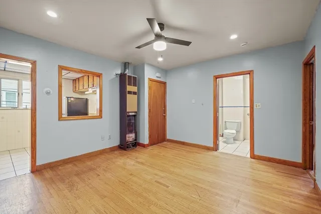 a view of an empty room with window and wooden floor