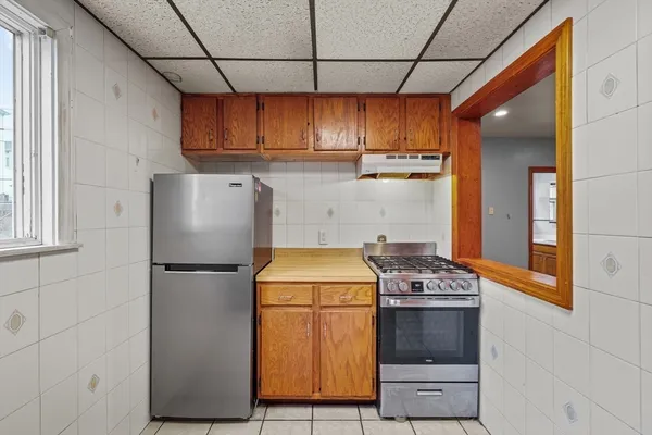 a kitchen with stainless steel appliances granite countertop a refrigerator a stove and a sink with wooden cabinets