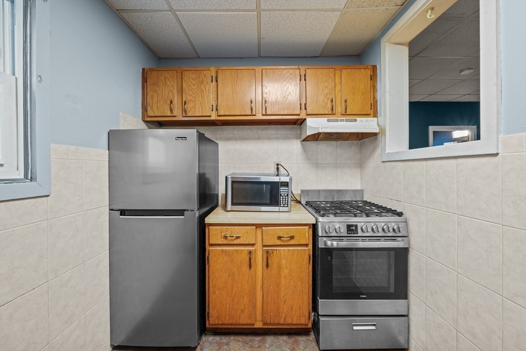 337 Columbia Street Fall River, MA 02721 - Photo 24 of 33 a kitchen with a stove a sink and a microwave