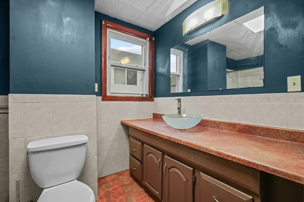a bathroom with a toilet sink and mirror