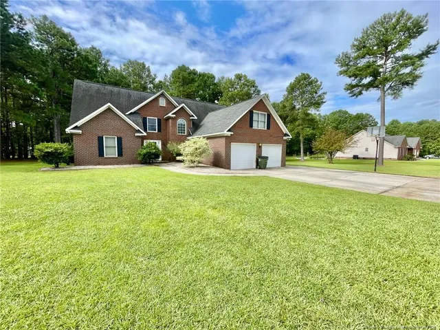 a house with a yard and trees in the background