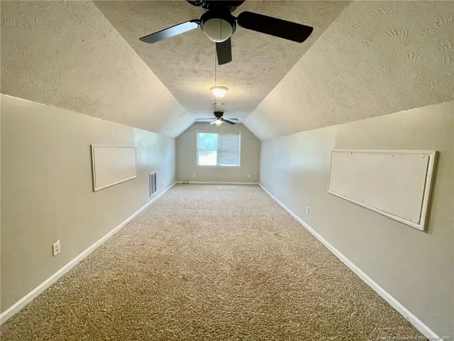 en empty room with windows and ceiling fan