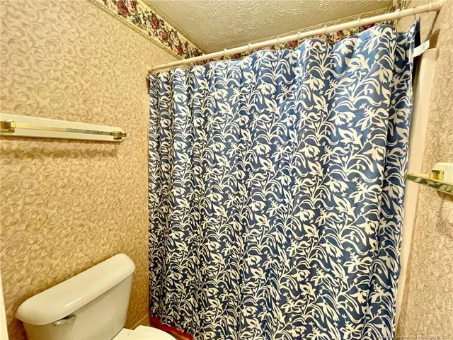a white toilet sitting next to a shower curtain