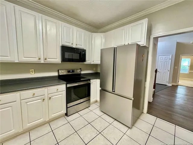 a kitchen with white cabinets and stainless steel appliances