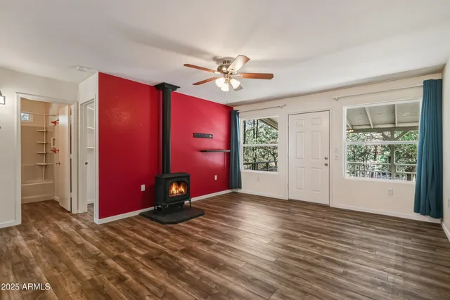 an empty room with windows closet and chandelier fan