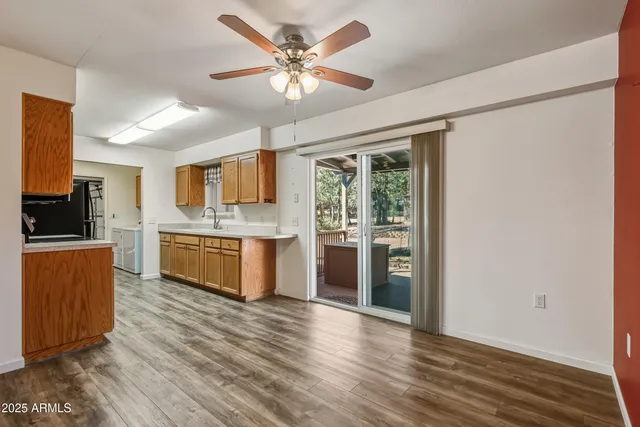 a large kitchen with stainless steel appliances granite countertop a stove a sink dishwasher and a refrigerator with wooden floor