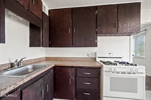 a kitchen with granite countertop a sink cabinets and stainless steel appliances
