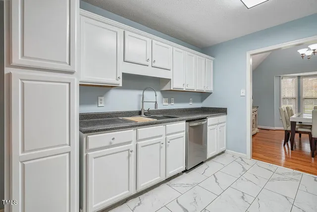 a kitchen with white cabinets and sink
