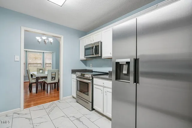 a kitchen with stainless steel appliances granite countertop a stove a sink and a refrigerator