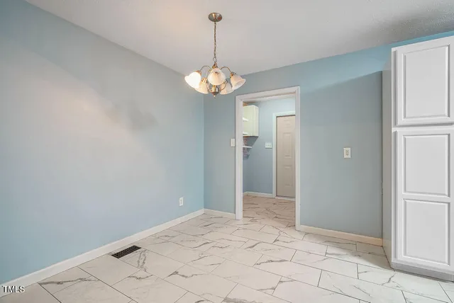 a view of a hallway with chandelier and entryway