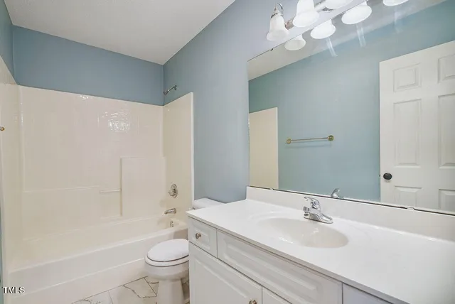 a view of an empty room with a ceiling fan and a large window