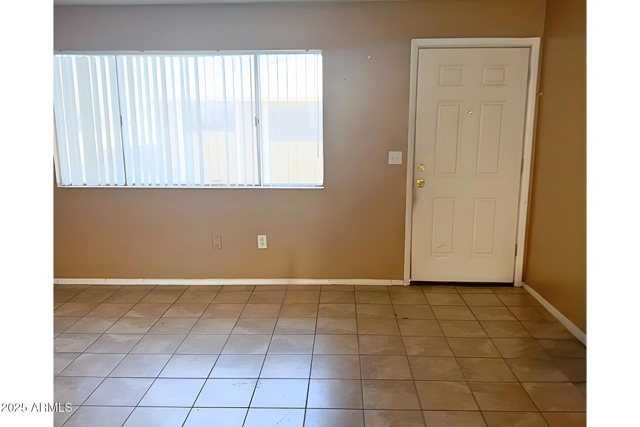 3313 West Harmont Drive, Unit 2 Phoenix, AZ 85051 - Photo 2 of 6 a view of a livingroom with an empty space and a window