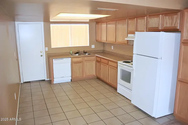 a kitchen with a refrigerator sink and cabinets