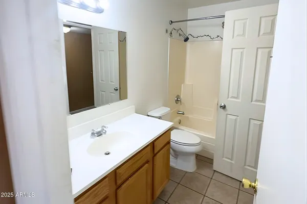 a view of a refrigerator in kitchen and an empty room