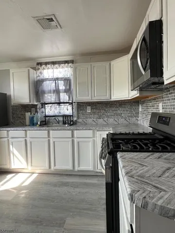 a kitchen with a stove a sink and a microwave