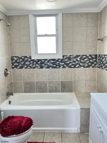 a bathroom with a bathtub a shower and a window