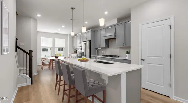 a kitchen that has a lot of cabinets a sink and appliances