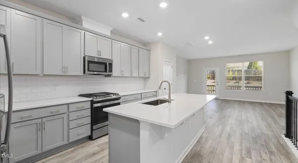 a kitchen with stainless steel appliances granite countertop a sink stove and cabinets